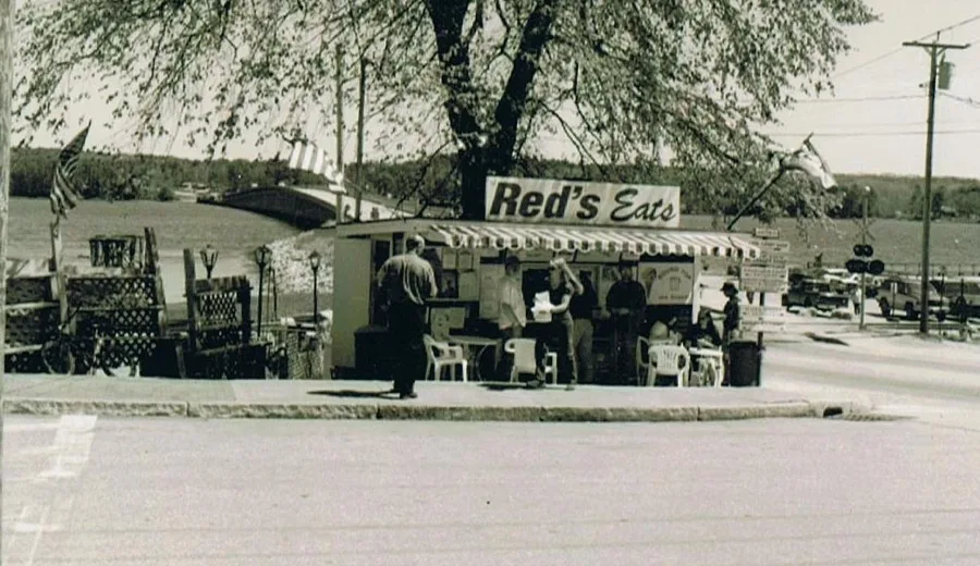 Black and white archival photo of the original Red's Eats stand under the elm tree in Wiscasset, Maine