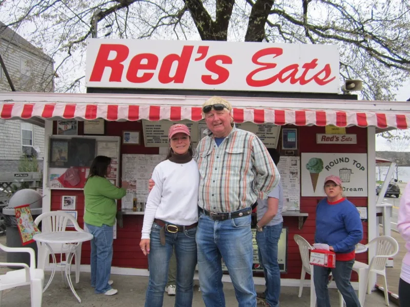 The red Red's Eats stand with the Round Top ice cream sign and customers ordering